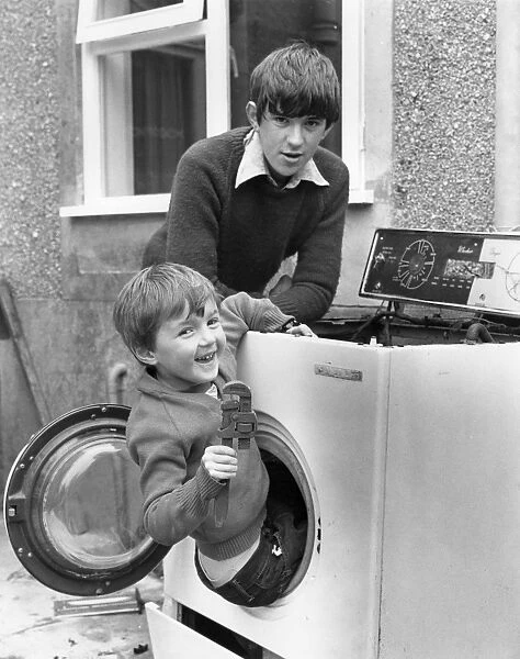 Two boys playing in old washing machine