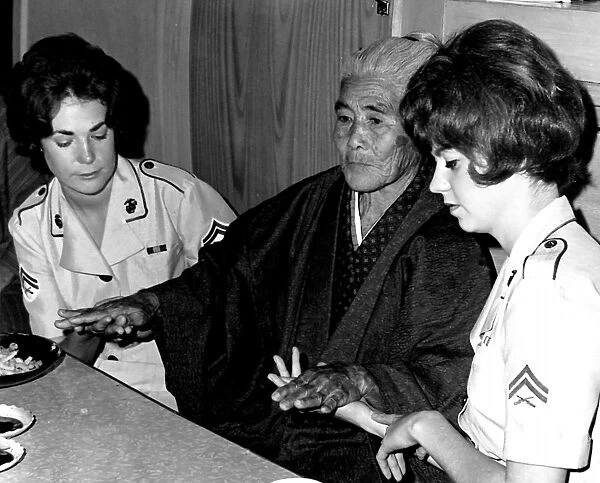 WOMEN MARINES, 1967. An elderly Okinawan woman showing her tattooed hands to American