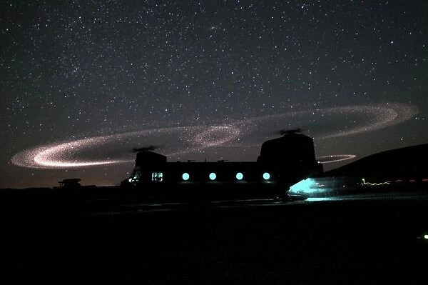 Dust lights up the rotors of a CH-47 Chinook helicopter