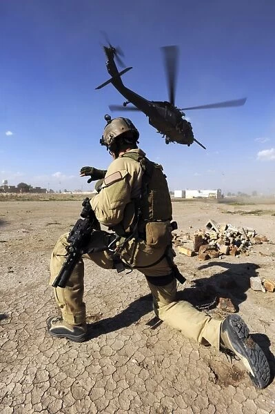 A soldier conducts security for an HH-60 Pavehawk helicopter