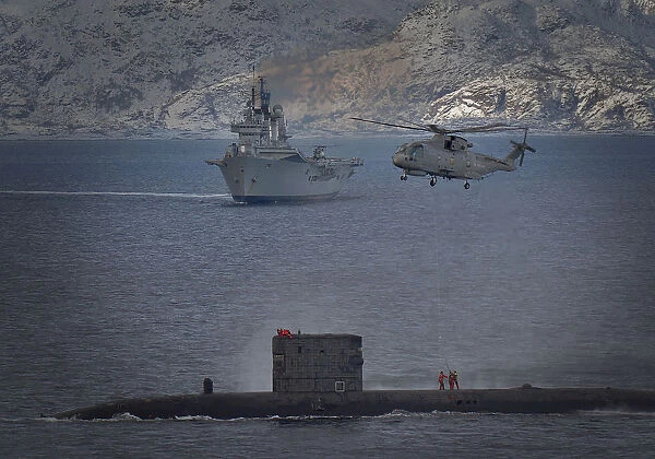 HMS Talent conducts a high line transfer with a Merlin helicopter as HMS Ark Royal