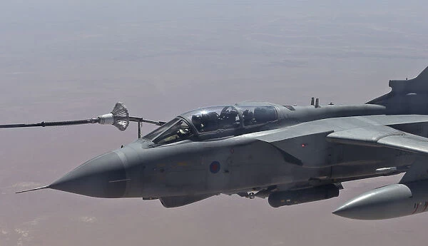An RAF Tornado GR4 takes on fuel from a Voyager tanker aircraft during an armed reconnaissance