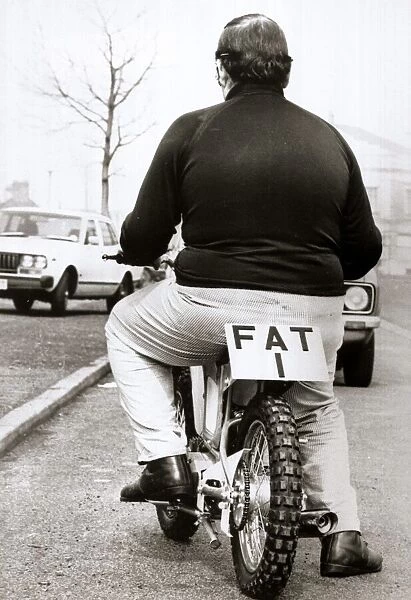Large man on a small motor cycle with FAT 1 as the licence Number
