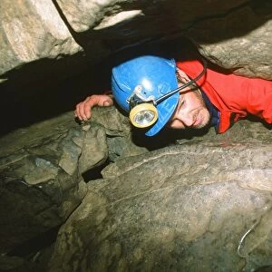 A caver in a tight squeeze in the Yorkshire Dales UK