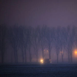 Vehicles drive through fog on a frosty road near Dragos Voda village