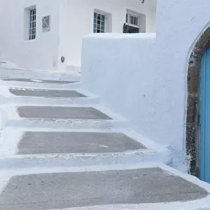 Greece, Santorini. Blue door livens up a quiet alley of white-washed homes in Pyrgos