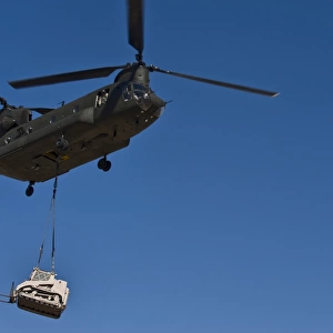 A U. S. Army CH-47 Chinook carries a bulldozer to a drop site