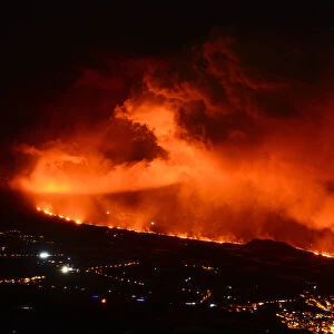 Lava flow and ash from erupting volcano passing close by the village of Los Llanos de Aridane, Volcano Cumbre en Vieja, La Palma, Canary Islands. November, 2021