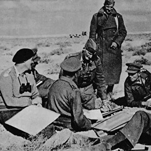 Maps and plans are spread on the sand, 1942 (1944)