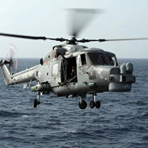 Helicopter Capturing Images Of A Lynx Landing On HMS Cornwall
