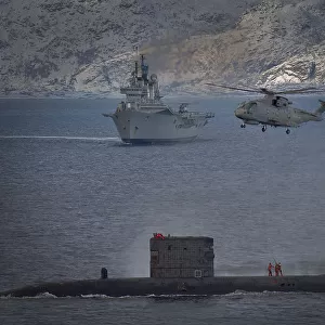 HMS Talent conducts a high line transfer with a Merlin helicopter as HMS Ark Royal