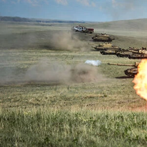 A line of Challenger 2s fire as part of the Royal Welsh Battle Group during Exercise