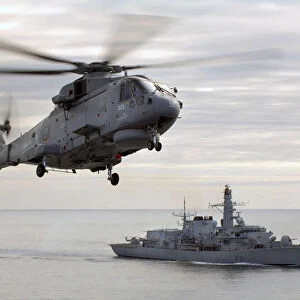 Merlin helicopter hovers over HMS Sutherland